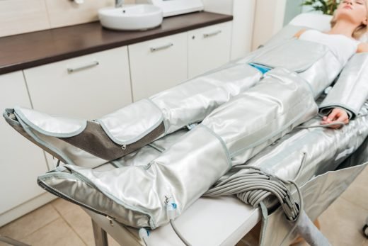 Selective focus on woman lying on beauty couch during pressotherapy session